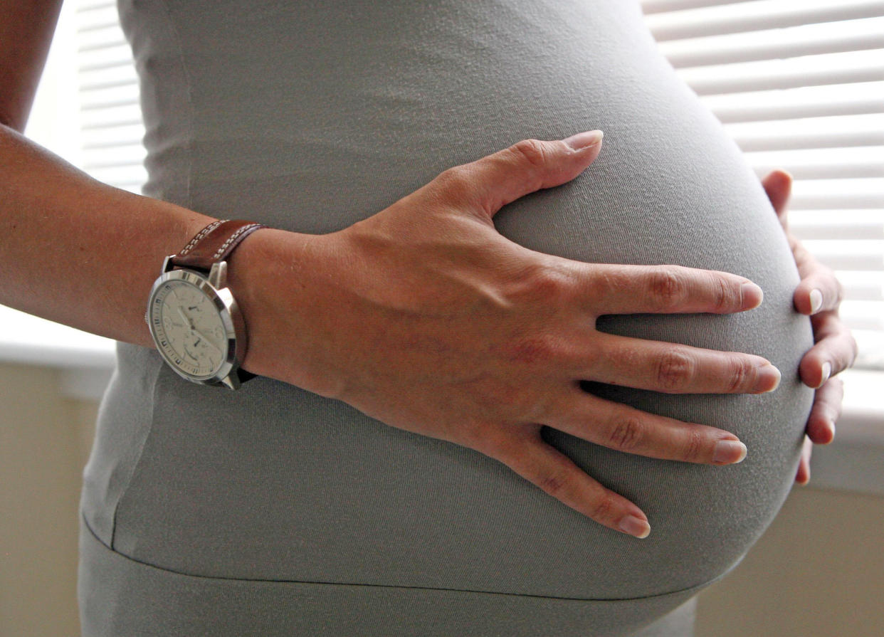 File photo dated 25/06/08 of a woman holding her stomach, eight months into her pregnancy as Chancellor George Osborne has announced in the budget that the health in pregnancy grant is to be scrapped.