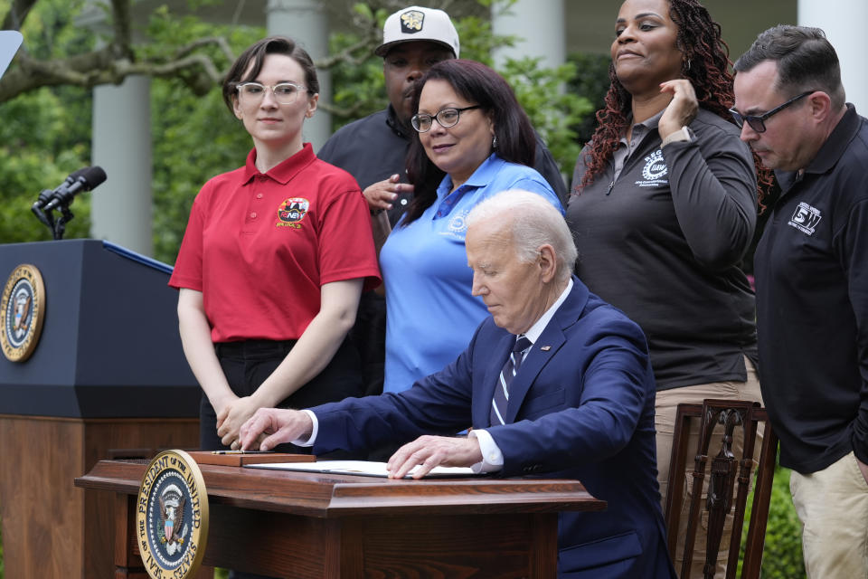 President Joe Biden sits down to sign a document in the Rose Garden of the White House in Washington, Tuesday, May 14, 2024, imposing major new tariffs on electric vehicles, semiconductors, solar equipment and medical supplies imported from China. (AP Photo/Susan Walsh)