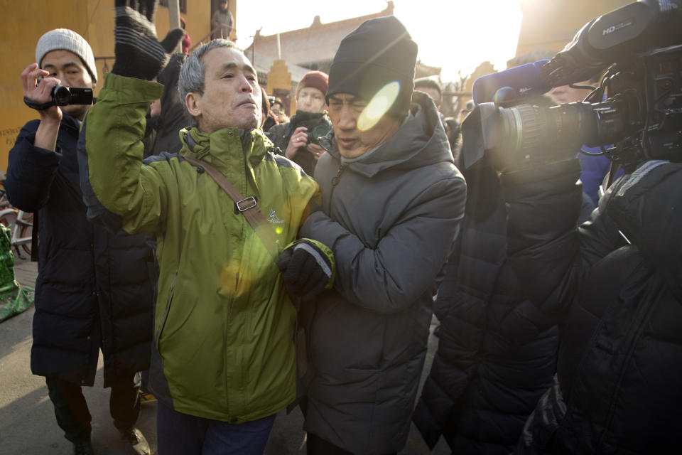 Plainclothes security officers take away a supporter of Chinese human rights lawyer Wang Quanzhang near the Secondary Intermediate People's Court of Tianjin northeastern China's Tianjin municipality, Wednesday, Dec. 26, 2018. The trial of Wang, who was charged with subversion of state power in 2016, was expected to begin at the court on Wednesday morning. (AP Photo/Mark Schiefelbein)