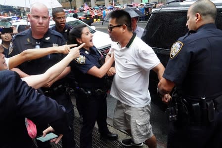 Police officers detain a man after scuffles broke out outside Grand Hyatt hotel, where Taiwan's President Tsai Ing-wen is supposed to stay during her visit to the U.S., in New York City