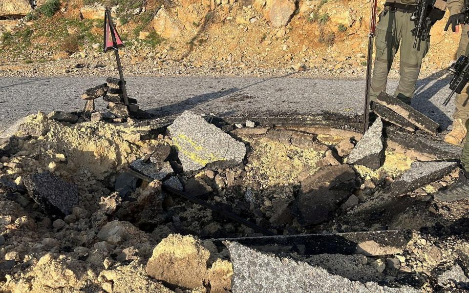 A view of a crater on a damaged road, after Iran's mass drone and missile attack, at a location given as Hermon area