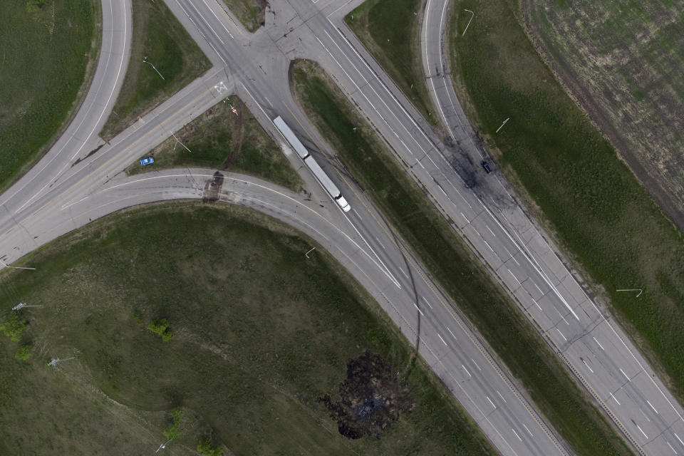 A scorched patch of ground where a bus carrying seniors to a casino ended up after colliding with a semi-trailer truck and burning on Thursday is seen on the edge of the Trans-Canada Highway near Carberry, Manitoba, Friday, June 16, 2023. Police said 15 people were killed and 10 more were sent to hospital. (Darryl Dyck/The Canadian Press via AP)