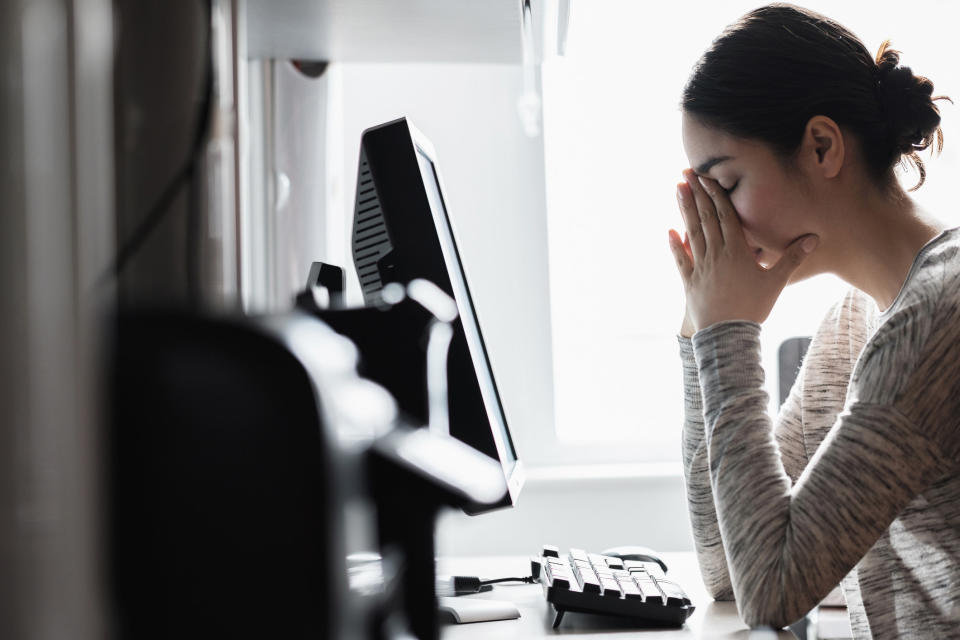 A woman looking stressed in front of her computer