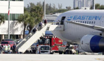 Passengers that came off the cruise ship Rotterdam Thursday, board a charter plane at Fort Lauderdale–Hollywood International Airport, Friday, April 3, 2020, in Fort Lauderdale, Fla. The Zaandam and a sister ship sent to help it, the Rotterdam, were given permission to unload passengers at Port Everglades on Thursday, after days of negotiations with officials who feared it would divert resources from a region with a spike in virus cases. (AP Photo/Wilfredo Lee)