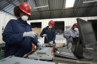 Employees dismantle laptop waste at WEEE center recycling plant, a collection point where people can deposit old electric equipment in Nairobi, Kenya Wednesday, March. 20, 2024. U.N. agencies have warned that electrical and electronic waste is piling up worldwide while recycling rates continue to remain low and are likely to fall even further. (AP Photo/Brian Inganga)