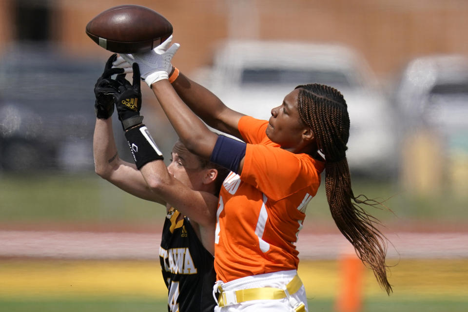 Midland receiver JaNasia Spand, right, and Ottawa defender Jennifer Anthony (14) reach for the ball during an NAIA flag football game in Ottawa, Kan., Friday, March 26, 2021. The National Association of Intercollegiate Athletics introduced women's flag football as an emerging sport this spring. (AP Photo/Orlin Wagner)