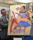 Cuban ambassador to the United States Jose Cabanas unveils a poster during a press conference at Fort Lauderdale airport, Florida, on August 31, 2016