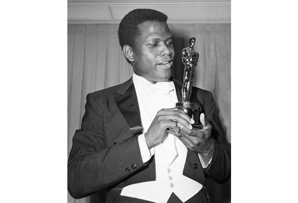 FILE - Actor Sidney Poitier appears with his Oscar for best actor, for his role in "Lillies of the Field," at the 36th Annual Academy Awards in Santa Monica, Calif., on April 13, 1964. Arizona State University has named its new film school after Poitier. The university, which is expanding its existing film program into its own school, says it has invested millions of dollars in technology to create one of the largest, most accessible and most diverse film schools. The Sidney Poitier New American Film School will be unveiled at a ceremony on Monday, Jan. 25, 2021. (AP Photo, File)