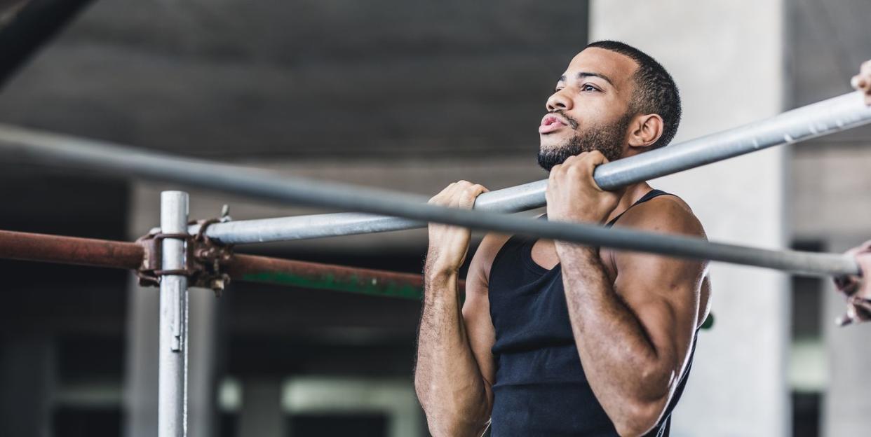 male athlete doing chin ups in a gym