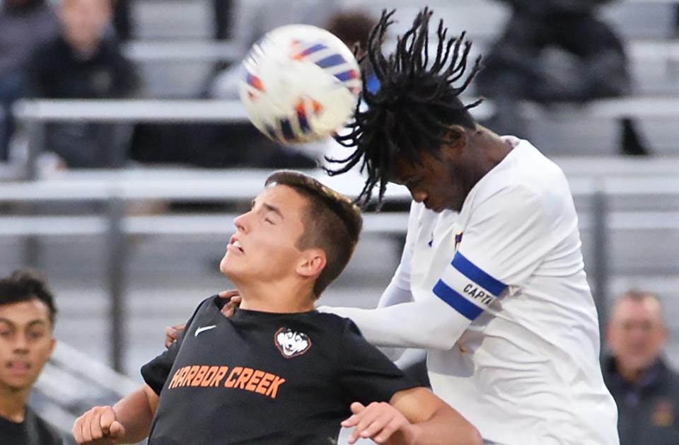 Harbor Creek High School senior Benjamin Wolfe, left, and Erie High senior Kyungu Kombe compete for a header during a soccer game in Harborcreek Township on Thursday.