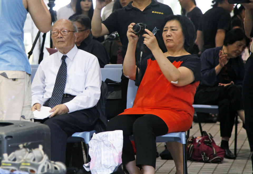 In this June 9, 2012 photo, Chinese journalist Gao Yu, front right, who was imprisoned for nearly 6 year in the 1990s on charges of leaking state secrets, takes photographs besides Chinese author Yao Jianfu, left, during an opening ceremony of Chinese artist Liu Xia's photo exhibition in Hong Kong. Prominent Chinese journalist Gao Yu has been "criminally detained" just weeks ahead of the 25th anniversary of the Tiananmen Square crackdown for allegedly leaking state secrets to a foreign news site, the state news agency Xinhua reported Thursday, May 8, 2014. (AP Photo/Kin Cheung)