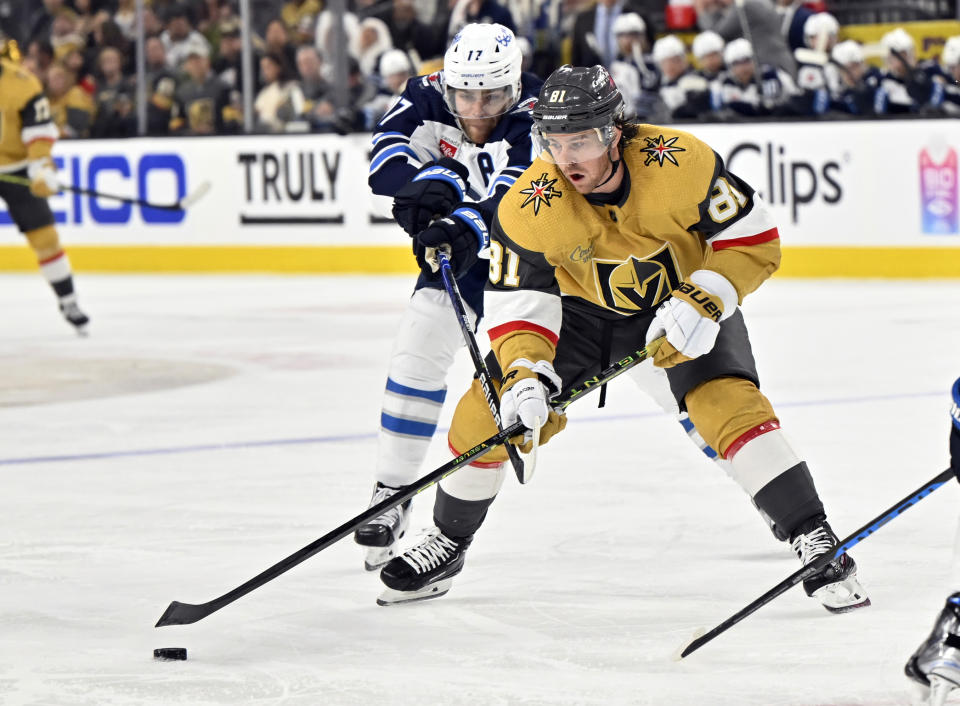 Vegas Golden Knights right wing Jonathan Marchessault (81) is defended by Winnipeg Jets center Adam Lowry (17) during the second period of Game 5 of an NHL hockey Stanley Cup first-round playoff series Thursday, April 27, 2023, in Las Vegas. (AP Photo/David Becker)