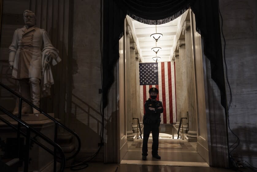 A U.S. Capitol Police officer stands at the door of the Capitol Rotunda near where the late U.S. Capitol Police officer Brian Sicknick will lie in honor Tuesday, Feb. 2, 2021, in Washington. Sicknick died after defending the Capitol on Jan. 6 against the mob that stormed the building and interrupted the electoral count after then-President Donald Trump urged supporters on the National Mall to "fight like hell" to overturn his defeat. (Salwan Georges/The Washington Post via AP, Pool)