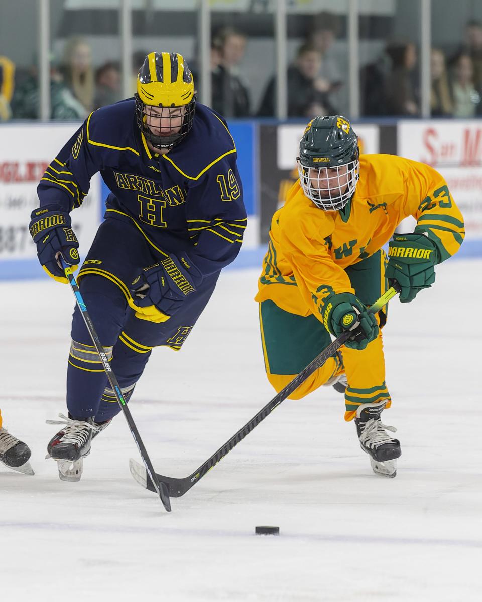 Howell's Dominic Giordano (23) and Hartland's LJ Sabala (19) race for the puck on Wednesday, Jan. 11, 2023 at 140 Ice Den.