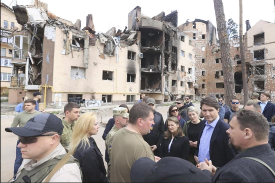 This image provided by the Irpin Mayor's Office shows Canadian Prime Minister Justin Trudeau, second from right, speaking with mayor Oleksandr Markushyn, center wearing t-shirt, in Irpin, Ukraine, Sunday, May 8, 2022. Trudeau made a surprise visit to Irpin on Sunday. The city was severely damaged during Russia’s attempt to take Kyiv at the start of the war. (Irpin Mayor's Office via AP)