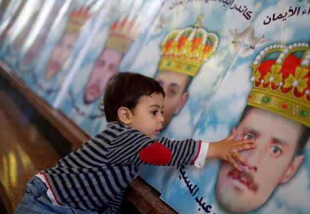 The son of one of the Egyptian Christians who were beheaded in Libya by Islamic State in 2015, touches his father's picture at a church in al-Our village south of Cairo, Egypt May 15, 2018. REUTERS/Amr Abdallah Dalsh