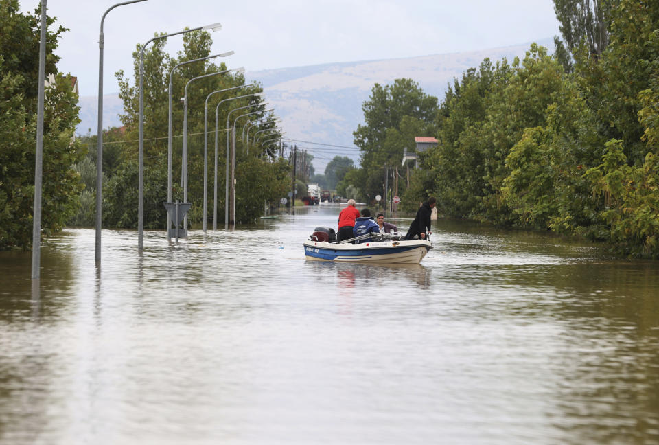 Local residents use a small boat during an evacuee operation from the village of Farkadona, Thessaly region, central Greece, Thursday, Sept. 7, 2023. Greece's fire department says more than 800 people have been rescued over the past two days from floodwaters, after severe rainstorms turned streets into raging torrents, hurling cars into the sea and washing away roads. (AP Photo/Vaggelis Kousioras)