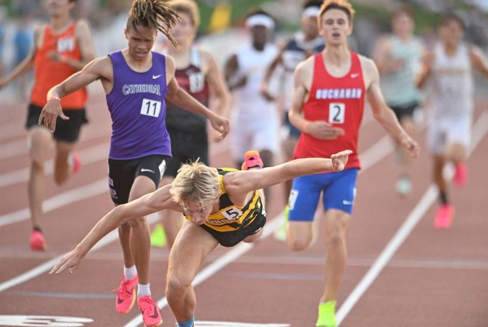 Hughson’s Joseph Lighthall , center, collapses past the finish line as he takes first in the Boys 800m Run at the 2023 CIF California Track & Field State Championship finals Saturday, May 27, 2023 in Clovis.