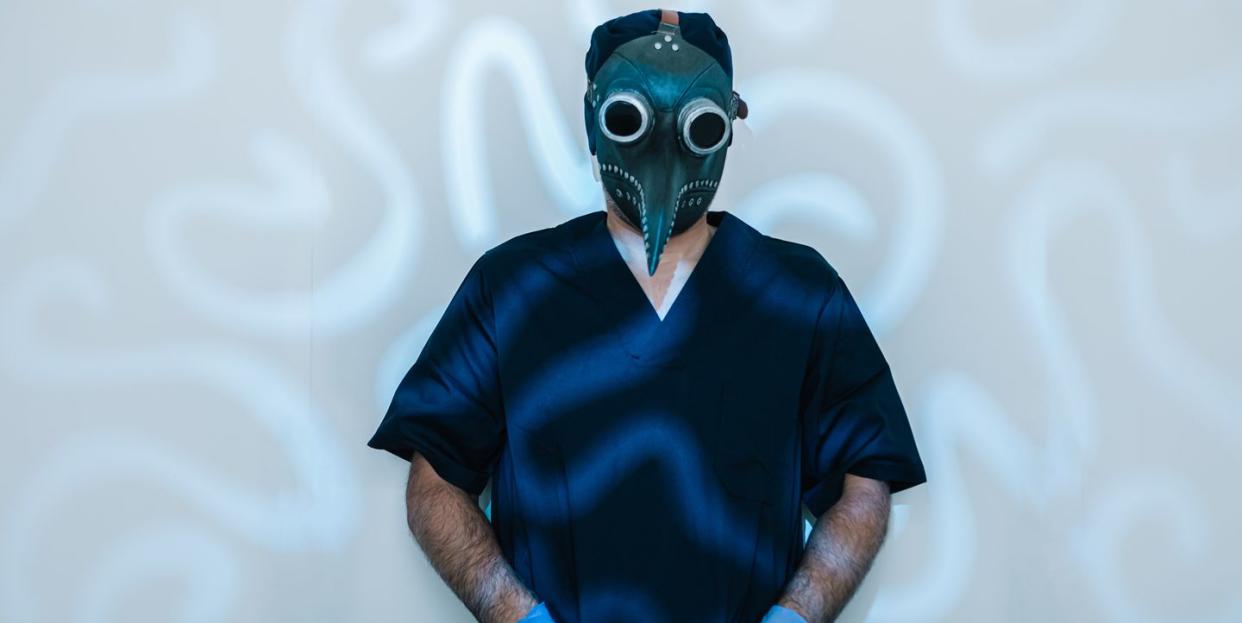 male doctor nurse wearing retro medieval era bubonic plague plague mask on white background with psychedelic figure