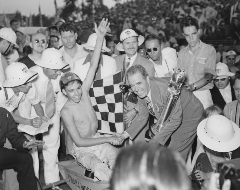 T.H. Keating, assistant general sales manager of Chevrolet, belatedly presents the winning trophy to Robert Berger, 14, of Omaha, Nebraska, during the All-American Soap Box Derby in Akron on Aug. 14, 1938.
