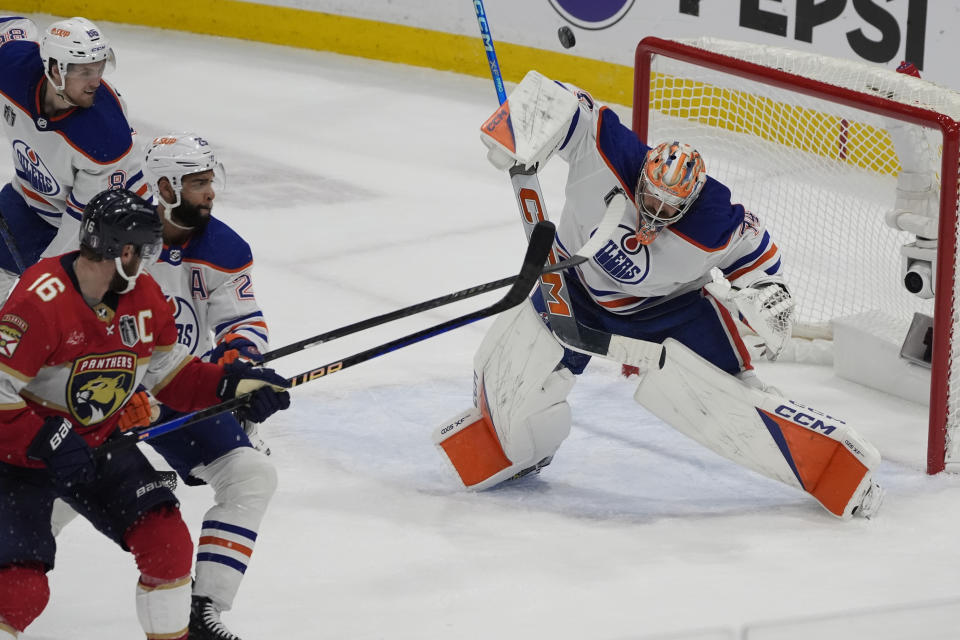 Edmonton Oilers goaltender Stuart Skinner (74) deflects a shot on goal during the third period of Game 5 of the NHL hockey Stanley Cup Finals against the Florida Panthers, Tuesday, June 18, 2024, in Sunrise, Fla. (AP Photo/Rebecca Blackwell)