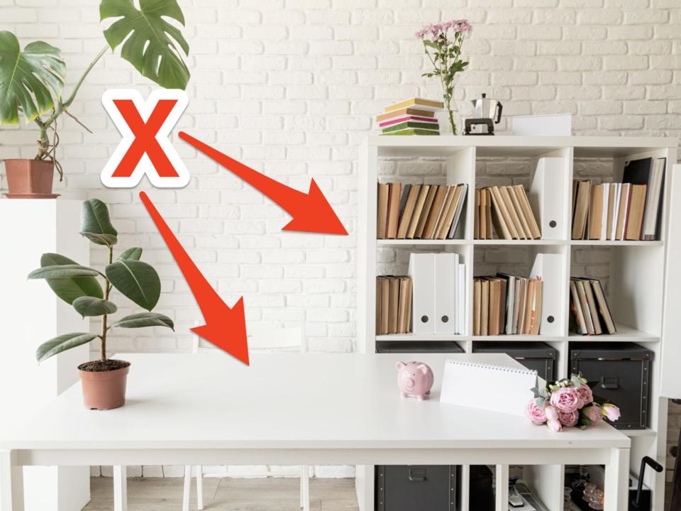 red arrows with an x pointing at white office space with desk, bookshelves, and plants