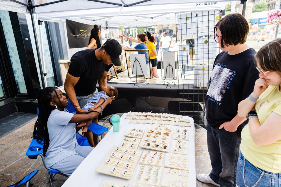 Ariane Hibo Ezeh, owner of Akissi Jewelry, speaks with customers during the Juneteenth celebration at The Gateway in Salt Lake City on June 19, 2023. | Ryan Sun, Deseret News