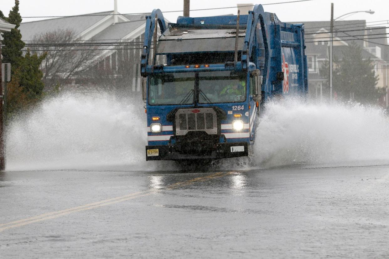 A garbage truck plows through high water along East Main Street in Manasquan Monday, December 18, 2023. Overnight rainfall across Monmouth and Ocean totaled more than three inches in some areas, and storm conditions resulted in flooding and downed trees that have left around 17,000 residents without power.