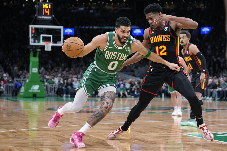 Boston Celtics forward Jayson Tatum (0) drives to the basket against Atlanta Hawks forward De'Andre Hunter (12) during the first half of an NBA basketball game Wednesday, Feb. 7, 2024, in Boston. (AP Photo/Charles Krupa)