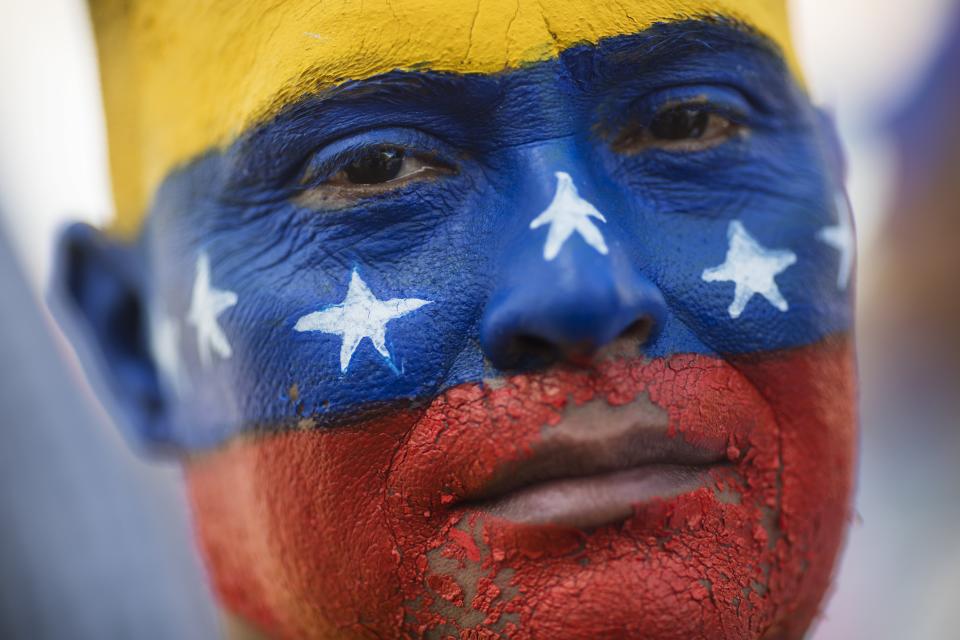 May Vera eyes the camera during a demonstration led by opposition politician Juan Guaido, who's urging masses into the streets to force President Nicolás Maduro from power, in Maracaibo, Venezuela, Saturday, Nov. 16, 2019. Vera's face was painted by his niece with the colors of Venezuela's national colors. Guaido called nationwide demonstrations to re-ignite a campaign against Maduro launched in January that has lost steam in recent months. (AP Photo/Rodrigo Abd)