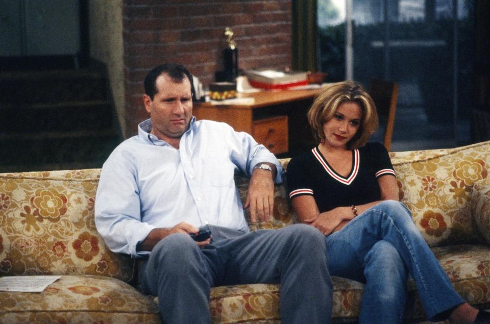 Christina sitting on a couch with Ed O'Neill in a scene from "Married... with Children"