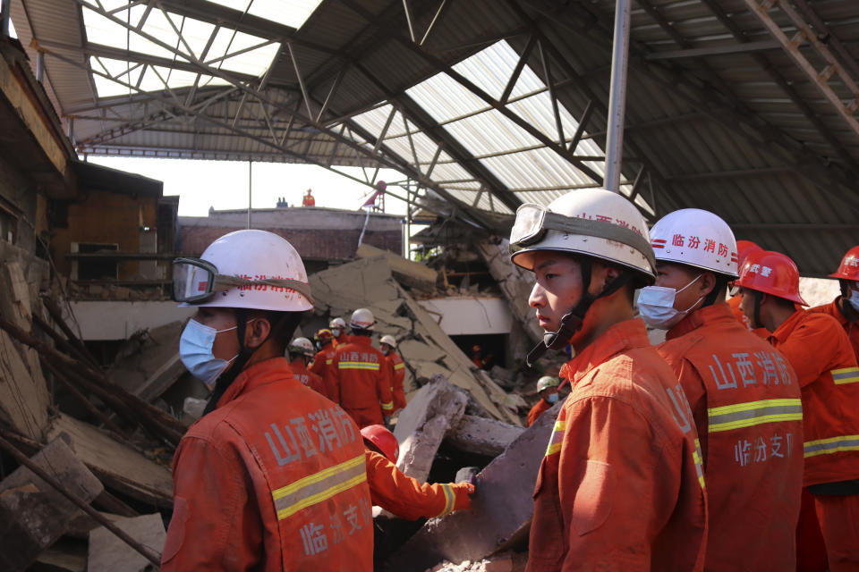 Rescuers search for victims in the aftermath of the collapse of a two-story restaurant in Xiangfen county in northern China's Shanxi province onAugust 29. Source: Chinatopix via AP