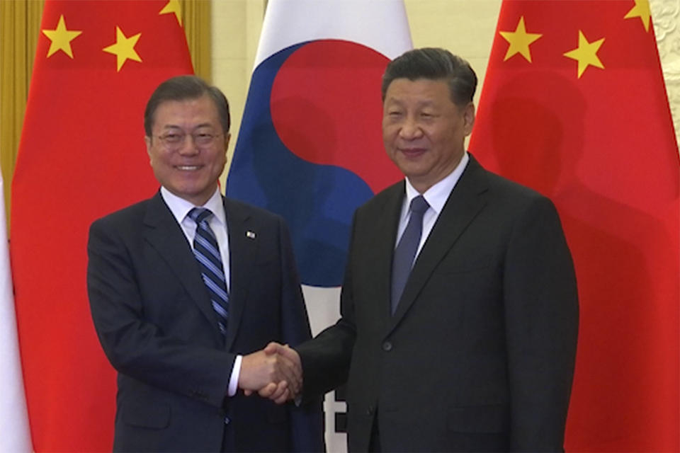 In this image from video, South Korean President Moon Jae-in, left, shakes hands with his Chinese counterpart Xi Jinping as they pose for photographers ahead of their meeting at the Great Hall of the People in Beijing, Monday, Dec. 23, 2019. The leaders of China, Japan and South Korea are holding a trilateral summit in China this week amid feuds over trade, military maneuverings and historical animosities. Most striking has been a complex dispute between Seoul and Tokyo, while Beijing has recently sought to tone down its disagreements with its two neighbors. (AP Photo)