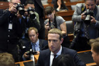 Facebook Chief Executive Officer Mark Zuckerberg, front right, is surrounded by photographers after arriving for a hearing before the House Financial Services Committee on Capitol Hill in Washington, Wednesday, Oct. 23, 2019, to discuss his plans for the new cryptocurrency Libra. (AP Photo/Susan Walsh)