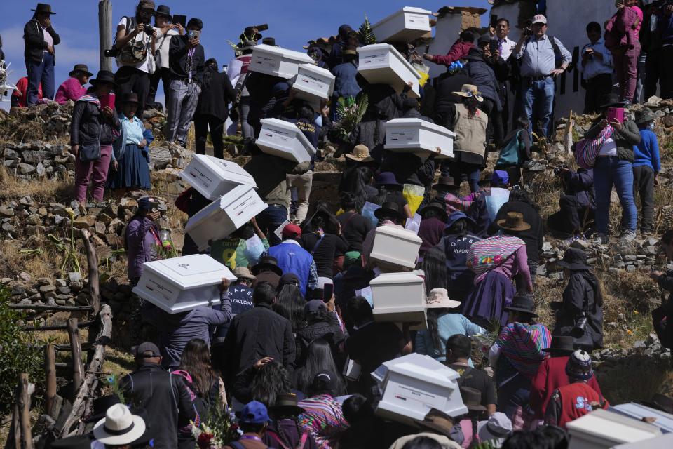 People carry the remains of relatives who were killed during the Maoist-inspired insurgency to the cemetery for burial after authorities recently identified and returned the remains to families in Accomarca, Peru, Friday, May 20, 2022. Peruvian authorities identified a group of 80 remains found in this community and another one nearby as men, women and children who were killed between 1980 and 2000 by both members of the Shining Path militant group and army soldiers. (AP Photo/Martin Mejia)