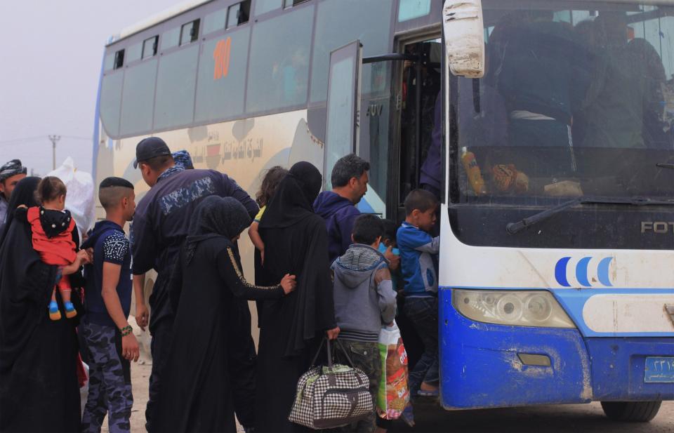 Having fled their home only weeks before, residents of Mosul board a bus to return