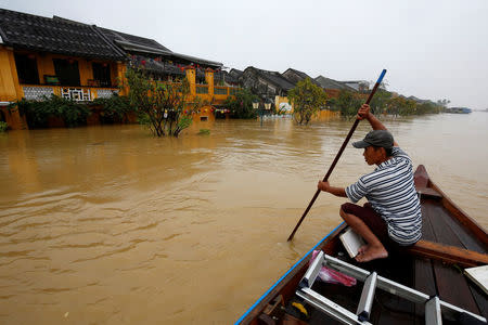 A man rides a boat along the overflowing Thu Bon river in UNESCO heritage ancient town of Hoi An after typhoon Damrey hits Vietnam November 6, 2017. REUTERS/Kham