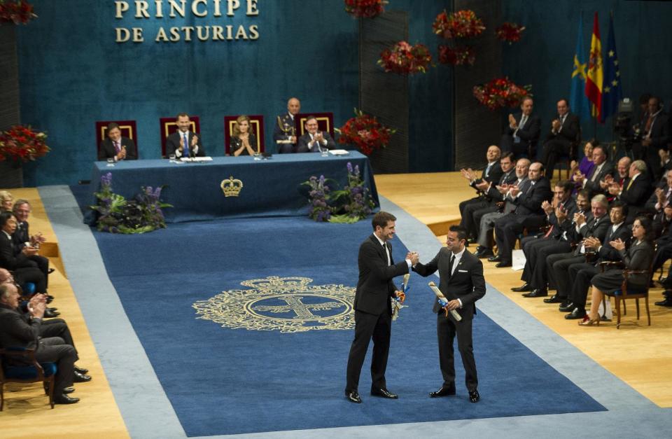 Prince of Asturias prize winners for Sports, Real Madrid soccer player Iker Casillas, center left, and FC Barcelona soccer player Xavi Hernandez, center right, shake hands during an awards ceremony in Oviedo Spain, Friday Oct. 26, 2012. The award is one of eight of Spain's prestigious Asturias prizes, presented by Crown Prince Felipe and granted each year in various categories. (AP Photo/Juan Manuel Serrano Arce)