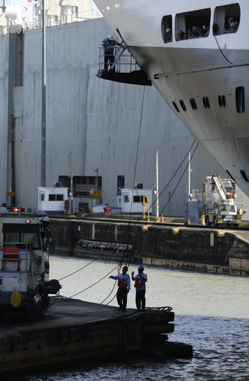 En esta imagen del 18 de enero de 2017, trabajadores del Canal de Panamá amarran un crucero a una locomotora en las esclusas de Pedro Miguel en el Canal de Panamá, en Paraíso, Panamá. La Autoridad del Canal declinó decir cuándo dinero se gasta en reparar las defensas dañadas en los muros del canal, o si esas reparaciones se han tenido que adelantar respecto al calendario previsto, y sólo dijo que se habían dedicado 1,7 millones de dólares en el mantenimiento de defensas en el canal original en 2015, el año anterior a inaugurar la ampliación. (AP Foto/Arnulfo Franco)