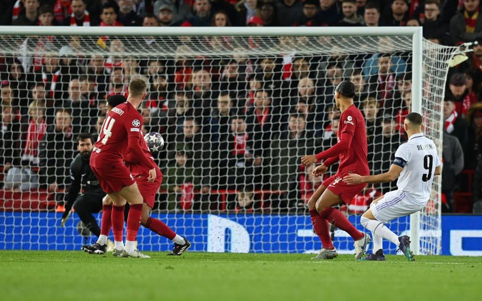 Karim Benzema of Real Madrid scores the team's fourth goal as players of Liverpool look on - Michael Regan/Getty Images