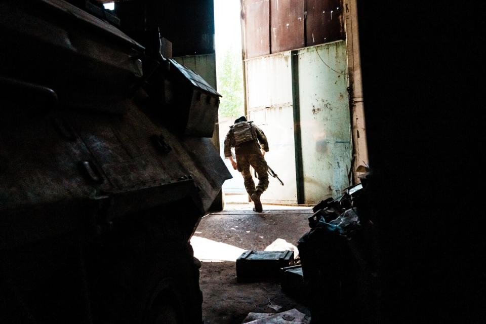 A Ukrainian soldier runs outside from a makeshift military base