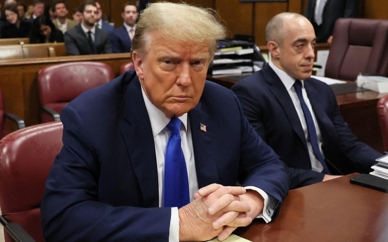 Donald Trump sits in the courtroom as his criminal trial over charges that he falsified business records to conceal hush money payments