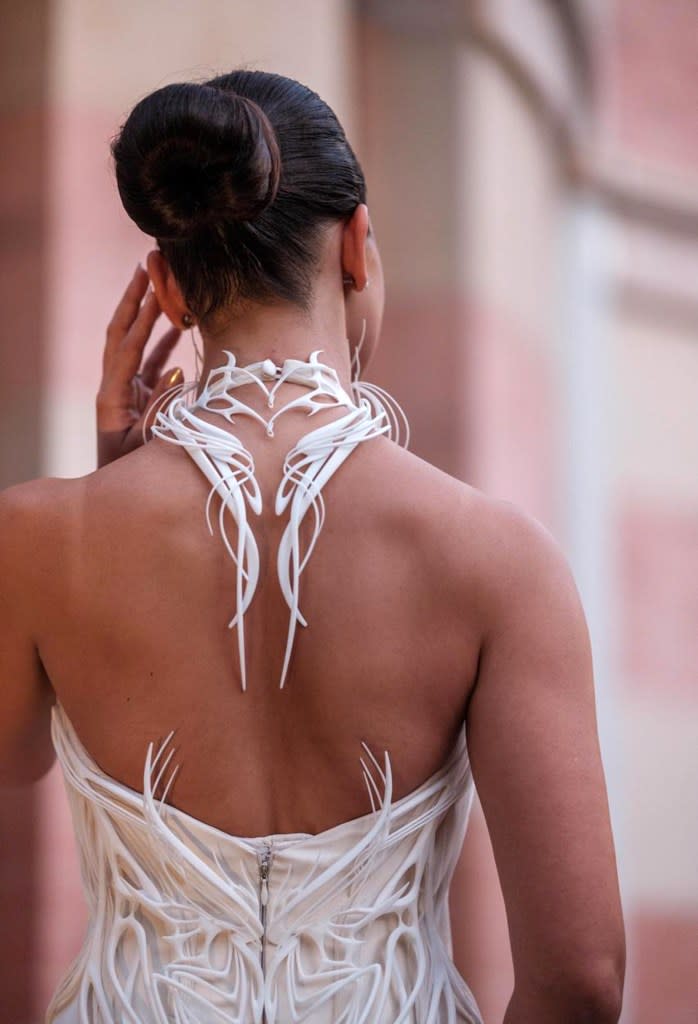 The structured bodice twists around the torso and up her neck like boney vines. Courtesy of EUKAWEDDINGS