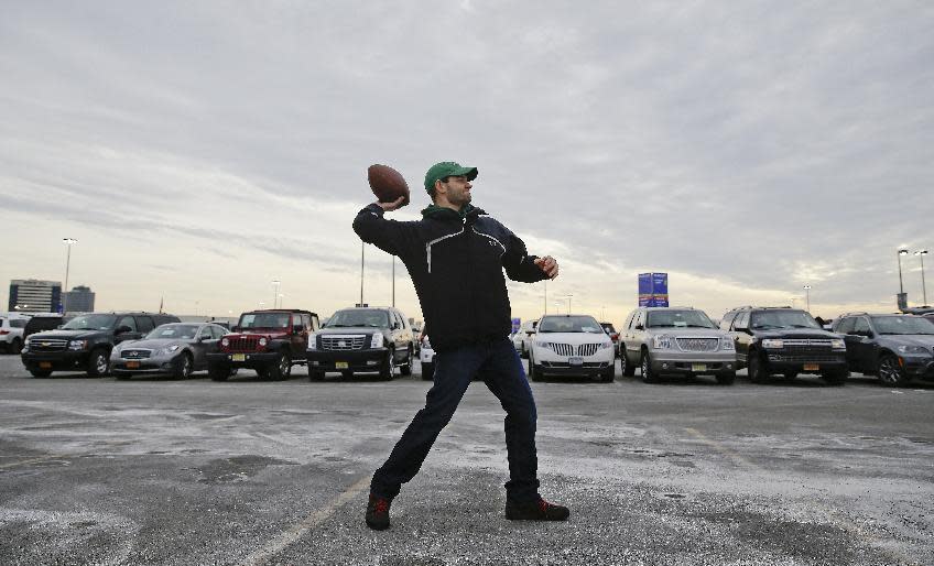 Matt Ciccone throws a football in the parking lot near MetLife Stadium before the NFL Super Bowl XLVIII football game between the Seattle Seahawks and the Denver Broncos Sunday, Feb. 2, 2014, in East Rutherford, N.J. (AP Photo/Seth Wenig)