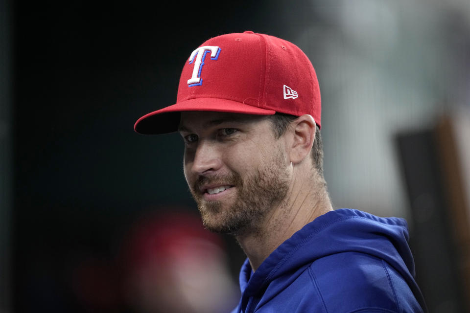 Texas Rangers pitcher Jacob deGrom talks with teammates in the dugout before a baseball game against the St. Louis Cardinals, Tuesday, June 6, 2023, in Arlington, Texas. (AP Photo/Tony Gutierrez)