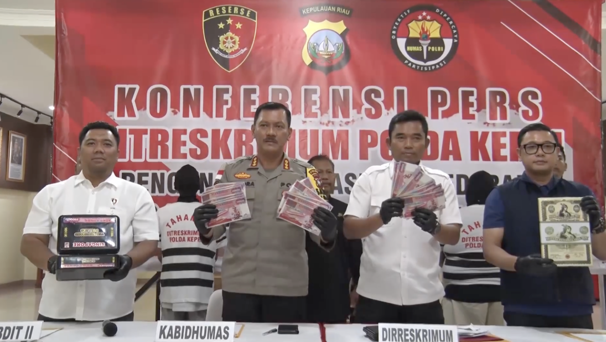 A screenshot from a video showcases Indonesian police officers presenting counterfeit banknotes, revealing the successful bust of a syndicate in November 2023.