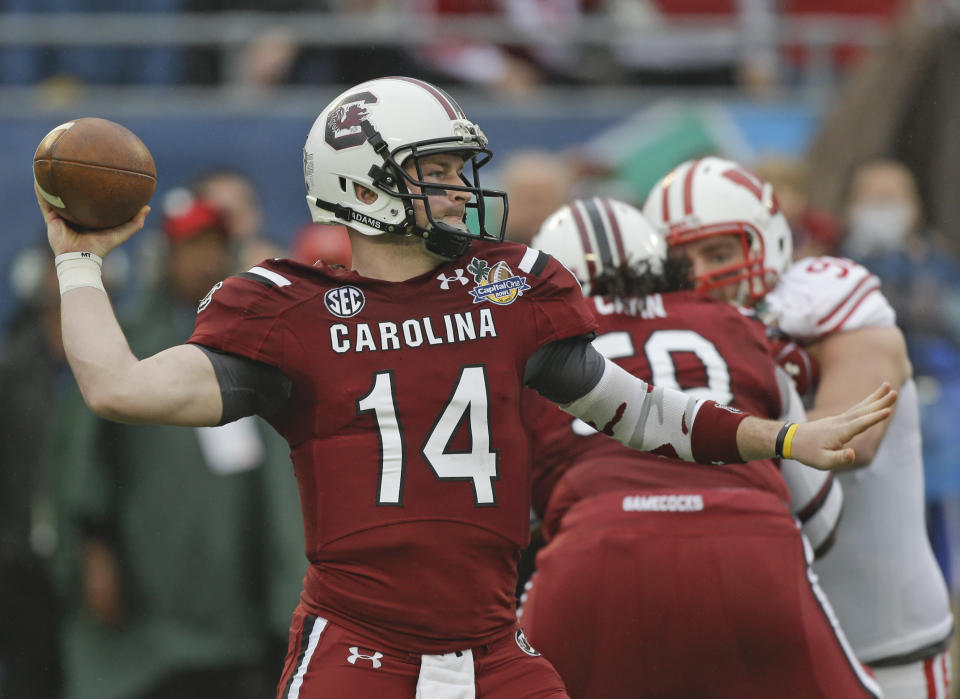 South Carolina quarterback Connor Shaw (14) throws a pass as he is rushed by Wisconsin defensive end Pat Muldoon, right, during the first half of the Capital One Bowl NCAA college football game in Orlando, Fla., Wednesday, Jan. 1, 2014.(AP Photo/John Raoux)