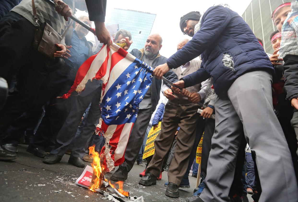 Iranian protesters set a U.S. flag on fire