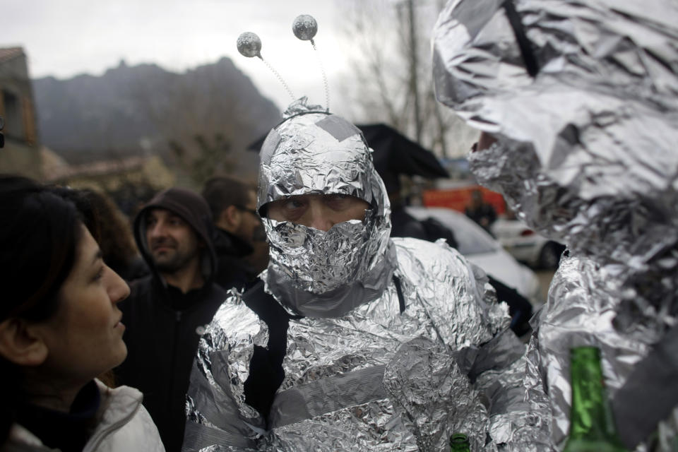 People in alien costumes stand on a street in the town of Bugarach, France, Friday, Dec. 21, 2012. Although the long expected end of the Mayan calendar has come, the New Age enthusiasts have steered clear from the sleepy French town of Bugarach, which gave some locals a chance to joke about the UFO legends that surround the area. (AP Photo/Marko Drobnjakovic)