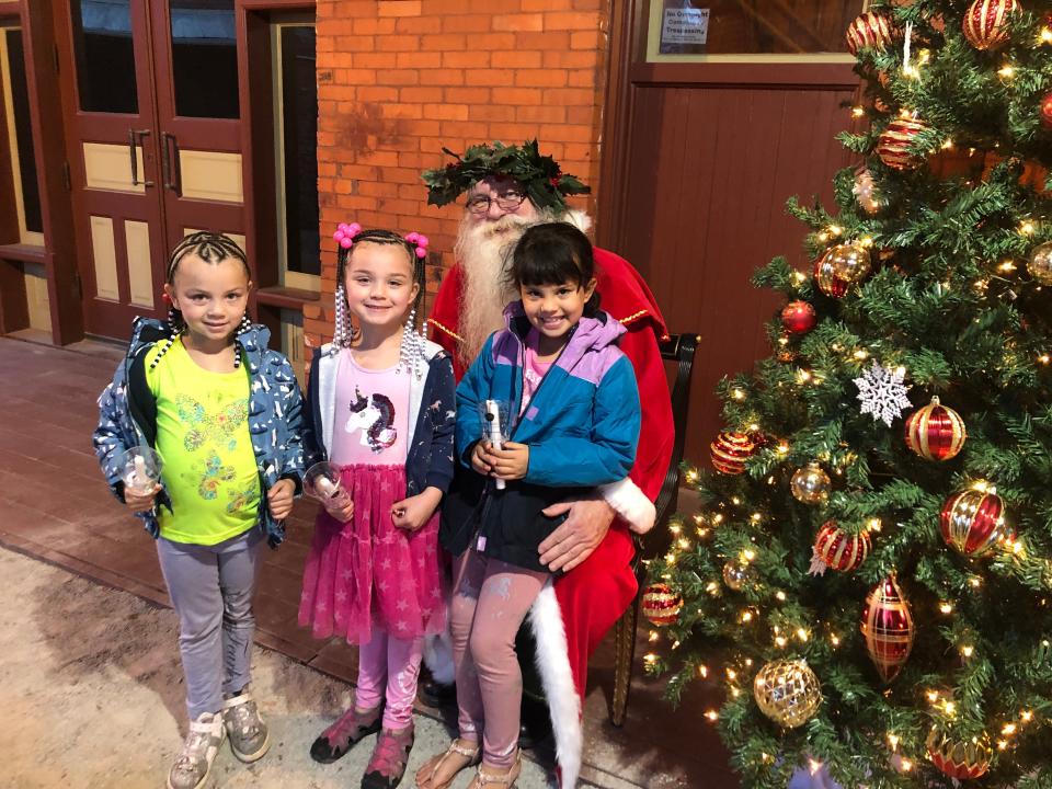 ‘Father Christmas’ poses with children at A Dickens Holiday on Nov. 25, 2022, in downtown Fayetteville, NC.